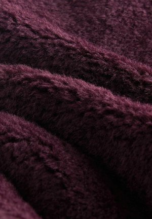 Material moale, texturat, de culoare burgundă închisă, care prezintă fibre pufoase și moi împletite cu un ușor luciu și modele subtile.