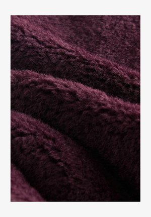 Mīksts, teksturēts audums dziļi burgundijas krāsā, kas parāda maigas, pūkainas šķiedras, kas savijas ar nelielu spīdumu un smalkām rakstiem.