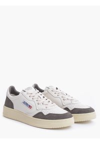 Scarpa da ginnastica bianca e grigia con materiali in pelle e scamosciato, punta arrotondata, parte frontale perforata per traspirabilità, lacci piatti e dettagli del logo.