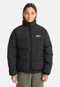 Giacca a vento nera imbottita con zip frontale, colletto alto e orlo elastico. Presenta pannelli trapuntati e un piccolo logo sul lato sinistro del petto.