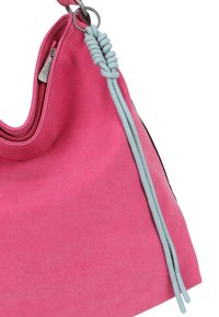 Borsa in suede rosa con una corda intrecciata blu attaccata a un anello d'argento e una cerniera visibile nella parte superiore.