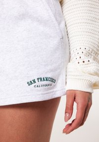 Šedá mikina na krátko s výšivkou "San Francisco California" v zelené barvě, vyrobená z měkké látky a s volným střihem.