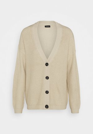 Cardigan beige en maille avec un col en V profond, des manches longues, des poignets et un ourlet côtelés, et quatre gros boutons noirs sur le devant.