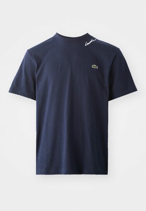 Navy blue short-sleeve t-shirt with a small green crocodile logo on the chest and white "Lacoste" text near the neckline.