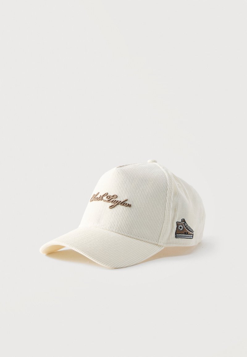 Casquette de baseball blanche en velours côtelé avec texte brodé marron « Chuck Taylor » sur le devant et petit écusson basket sur le côté.