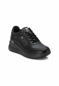 Zapatilla deportiva negra con cuero texturizado y acentos de malla, puntera redonda, suela acolchada y sistema de cordones de seis ojales, con logo metálico.