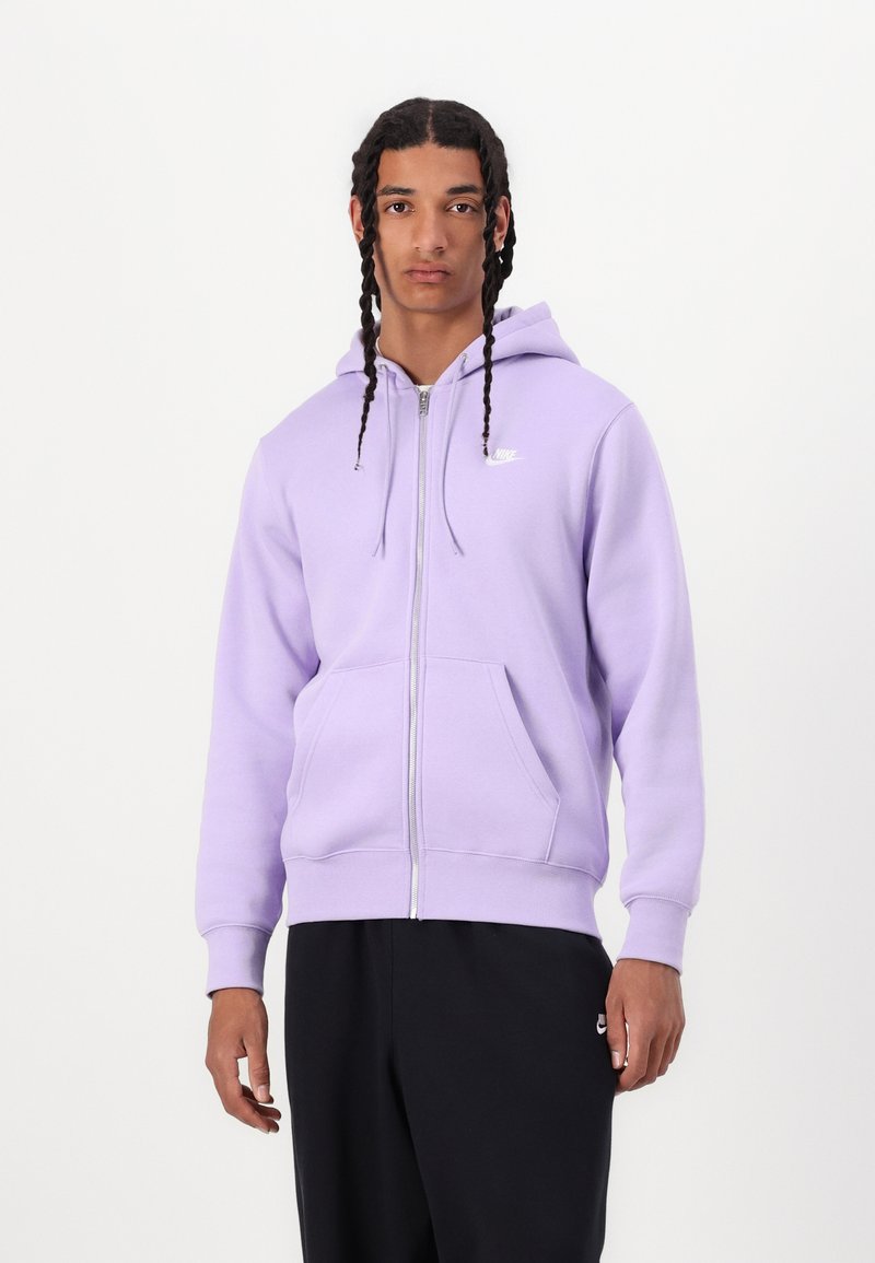 Ljuslila zip-up hoodie med känguruficka, ribbade ärmslut och nederkant. Har en liten vit Nike-logga på bröstet.
