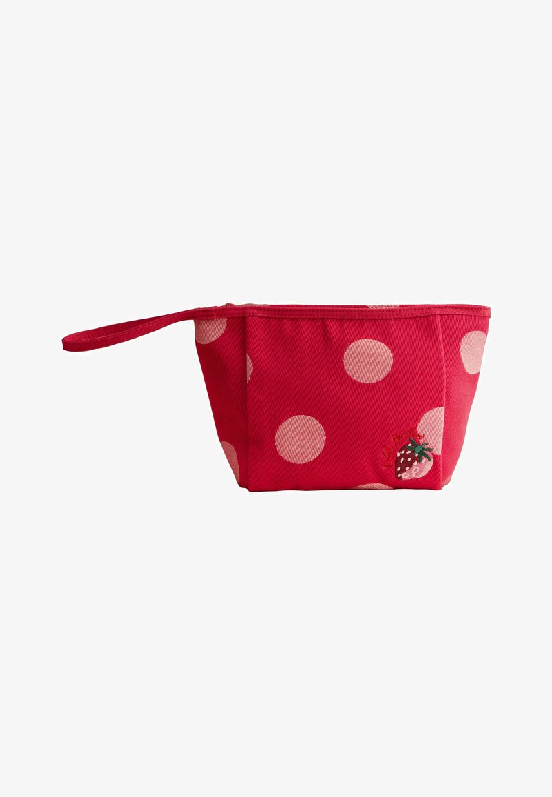 Pochette bracelet en tissu rouge avec de grands pois roses et une petite fraise brodée près du coin inférieur droit.
