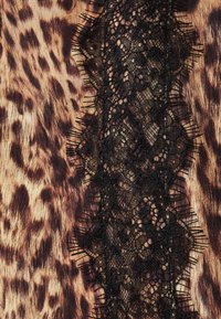 Tessuto leopardato con una bordatura in pizzo nero текстurizzata che corre verticalmente, caratterizzato da motivi intricati e bordi sfilacciati.