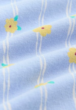 Svetlomodrá látka s textúrovaným povrchom, na ktorej sú žlté kvety s červenými stredmi a zelenými listami, oddelené bielymi čiarami.