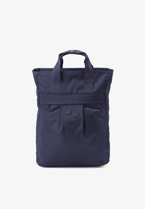 Marineblaue Tragetasche mit zwei Griffen, zwei vorderen Druckknöpfen und einem breiten, horizontalen Riemen über der oberen Vorderseite.