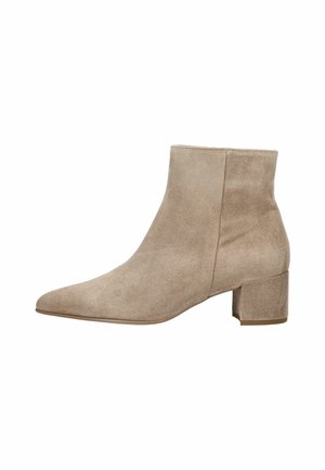 Beige suède enkellaarsje met een lage blokhak, spits toelopende neus en zonder zichtbare sluitingen of versieringen.