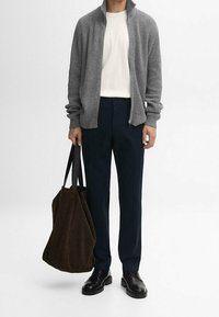 Cardigan grigio a coste con zip, t-shirt bianca, pantaloni scuri, scarpe in pelle nere e una borsa a tracolla in suede marrone. Design semplice e moderno.