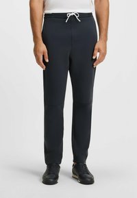 Marina joggers i stretchigt tyg med dragsko i midjan, med slim fit och sidofickor. Kombineras med svarta sneakers.