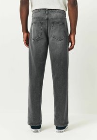 Tumehallid denim-püksid sirge lõikega, viie tasku disainiga ja keskmise kõrgusega vöökoht. Omavad klassikalisi tikkimisaktsente ja pehmet tekstuuri.