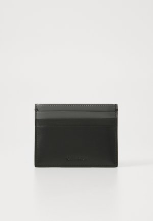 Tarjetero de cuero negro con múltiples ranuras para tarjetas, textura suave y bordes cosidos. En la parte frontal, lleva el nombre de la marca en relieve.