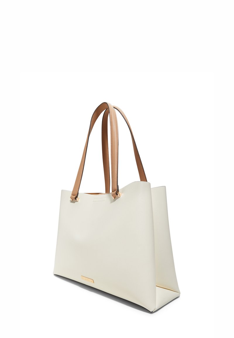 Sac fourre-tout en simili cuir blanc avec deux poignées tan, forme angulaire, texture lisse et logo subtil à l'avant.