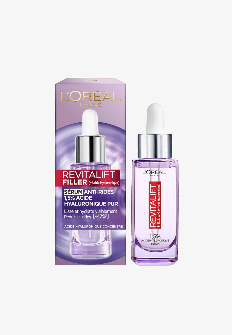 Boîte violette avec accents argentés, contenant un flacon compte-gouttes en verre clair. L'étiquette du produit indique "Revitalift Filler", avec des détails sur l'acide hyaluronique.