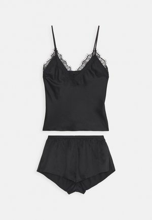 Conjunto de pijama em satin preto, apresentando um top com rendas e alças ajustáveis, acompanhado de calções combinando com cintura elástica.