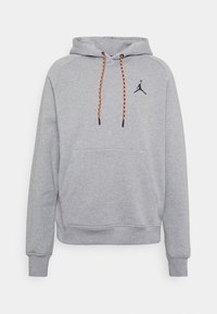 Grå hoodie med känguruficka, svart logotyp på bröstet och flätade orangea snören. Tillverkad av mjukt, strukturerat tyg.