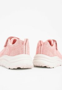 Rosa Netz-Sneaker mit einer strukturierten Oberseite, weißen Gummisohlen und einem Klettverschluss. Enthält einen subtilen gestreiften Akzent an der Ferse.