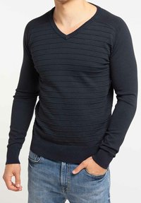 Tmavě modrý svetr s výstřihem do V, žebrovanou strukturou a horizontálními pruhy, vyrobený z měkkého materiálu. Dlouhé rukávy a přiléhavý střih.