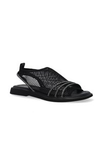 Sort net sandal med åben tå, med dekorative metalbånd og flad sål, placeret på en hvid baggrund.