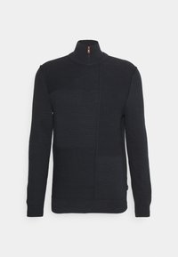 Czarny sweter z wysokim kołnierzem, z półzamkiem. Dzianina ma strukturę w patchworkowym designie oraz prążkowane mankiety.