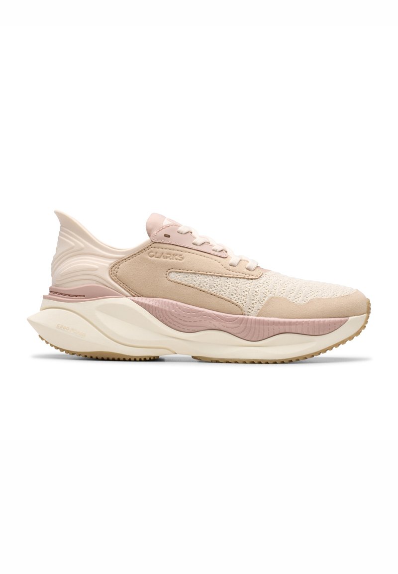Zapatilla ligera con una combinación de colores beige y rosa. Presenta una parte superior de tejido texturizado, detalles de ante y una suela de goma gruesa.