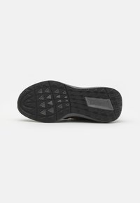 Black rubber shoe sole with a textured surface featuring triangular patterns and a branded rectangular accent labeled "LACOSTE."