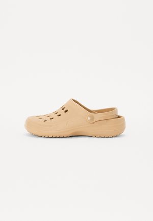Zoccoli beige realizzati in materiale leggero e flessibile, dotati di fori di ventilazione, una cinghia posteriore e una suola texturizzata per una migliore aderenza.