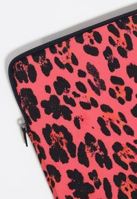 Bolsa de tela rosa con estampado de leopardo negro y acentos naranja ocasionales, acabada con un zipper y ribete negro.