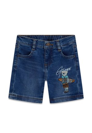 Pantaloncini di jeans blu scuro con tasche frontali e orsetto ricamato che tiene una tavola da surf con la scritta "Guess" sulla gamba destra.