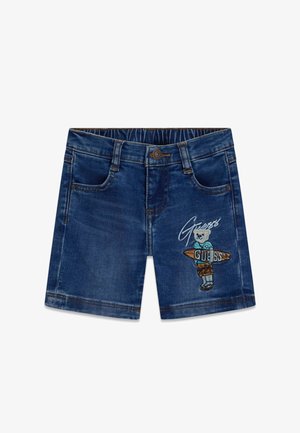 Pantaloncini di jeans blu scuro con tasche frontali e orsetto ricamato che tiene una tavola da surf con la scritta "Guess" sulla gamba destra.