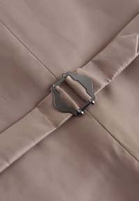 Light pink fabric with a smooth texture features a silver metallic buckle. The buckle is an adjustable style, neatly integrated into the design.