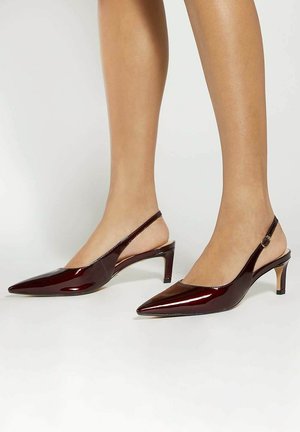 Burgundy patent slingback heels with pointed toes, slender mid-heels, and a buckle accent on the ankle strap. Smooth, glossy texture.