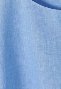 Tela de lino azul claro con una textura suave, que presenta un sutil patrón de tejido. El borde es redondeado, mostrando un diseño limpio y minimalista.