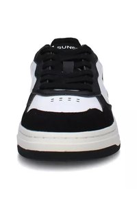 Sneaker con tomaia in suede nero e pelle bianca, linguetta imbottita, punta rotonda e suola in gomma nera. Presenta leggerissime perforazioni per la traspirabilità.