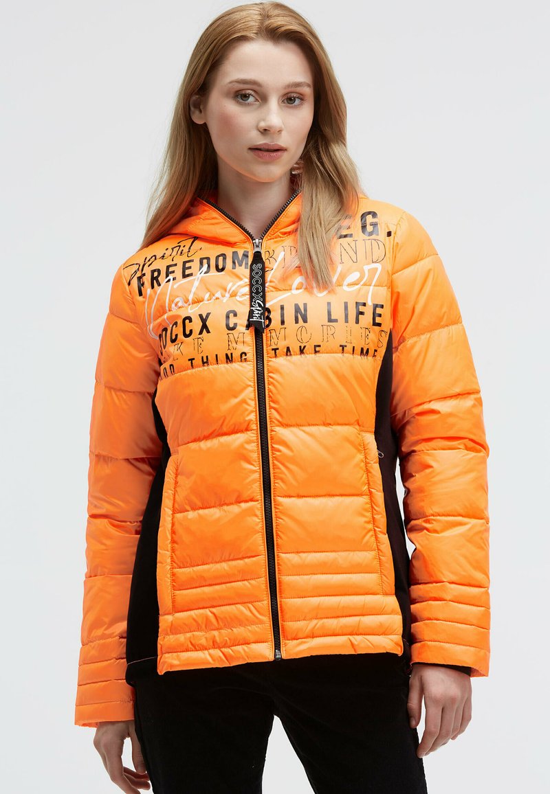 Padded jacket in bright orange with black accents, featuring a zip closure and printed text designs on the front. Smooth texture, hooded.
