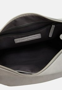 Helle graue Ledertasche mit einer strukturierten Oberfläche, ausgestattet mit einem dunklen Innenraum und einer Reißverschlusstasche, beschriftet mit "DENIM".