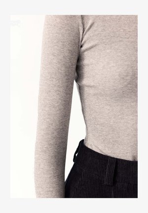 Szary prążkowany longsleeve połączony z czarnymi spodniami z korduroju o teksturowanej tkaninie i dopasowanej talii.