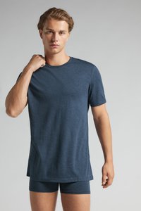 Mörkblå t-shirt med kort ärm i lätt tyg, rundad halsringning. Tillsammans med matchande mörkblå kalsonger, minimal detaljering.