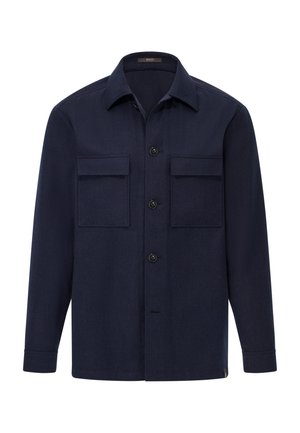 Chaqueta de camisa de manga larga azul marino con cuello, cierre de botones y dos grandes bolsillos en el pecho con solapa sobre fondo blanco liso.