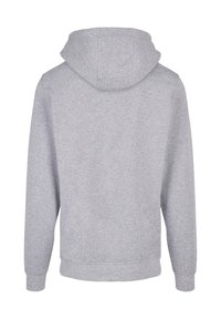 Szürke kapucnis pulóver puha, texturált anyagból. Lazán illeszkedő fazon, hosszú ujjak és kenguru zseb jellemzi. A hátulról készült nézet látható.
