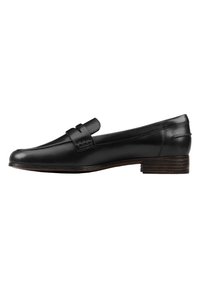 Mocassins en cuir noir à talon plat, présentant un accent tissé sur le coup de pied et une finition lisse et polie. Design épuré et élégant.