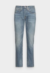 Jeans de mezclilla azul claro con corte recto, que cuentan con cinco bolsillos y un cierre frontal con botón. Aspecto desgastado con un desvanecimiento sutil.