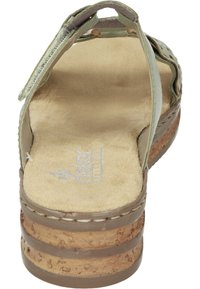 Green leather sandal with a textured upper, cork sole, and a padded footbed; features a back strap and decorative cutouts.