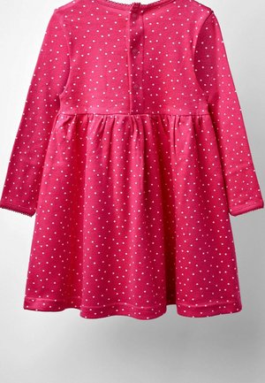 Vestido rosa de manga larga en tejido suave, con lunares blancos, cintura fruncida y cierre de botones en la parte posterior con borde ondulado.