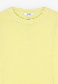 T-shirt gialla a girocollo realizzata in tessuto morbido, con una texture sottile e maniche corte, dotata di un'etichetta bianca con la scritta "SCALPERS" e taglia "S".