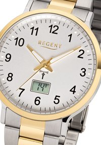 Montre en argent et or avec un cadran rond, marqueurs d'heure clairs, chiffres noirs et un affichage numérique à 6 heures. Bracelet en métal avec un mélange de finitions.